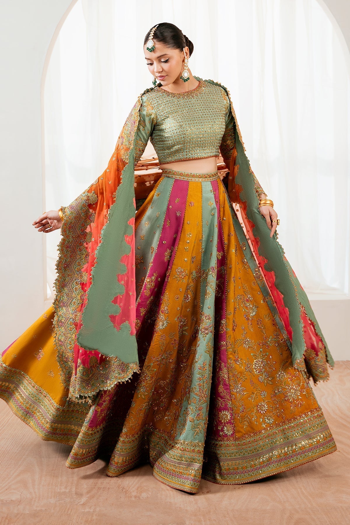 Embroidered silk lehenga set side view with orange dupatta draped