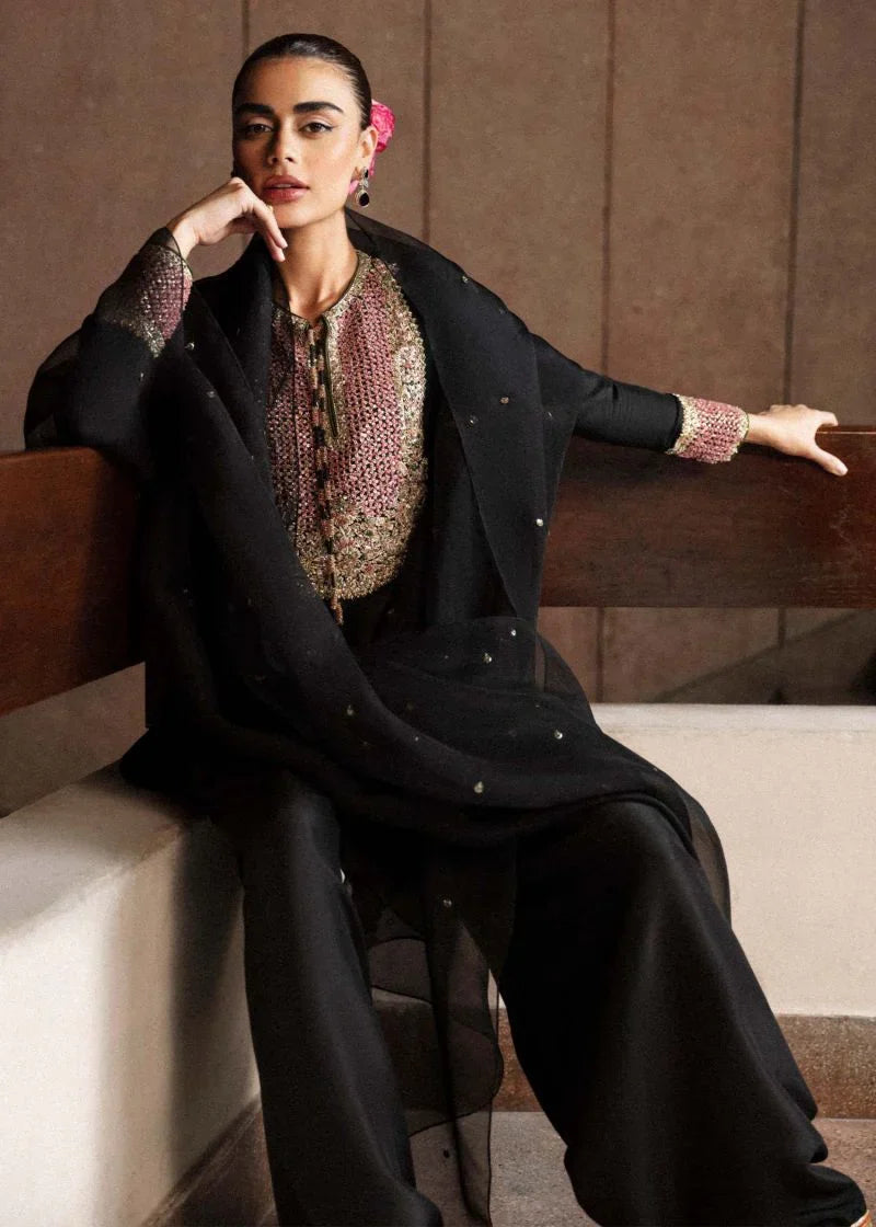 Char black formal outfit seated view showing draped dupatta and embroidered cuffs
