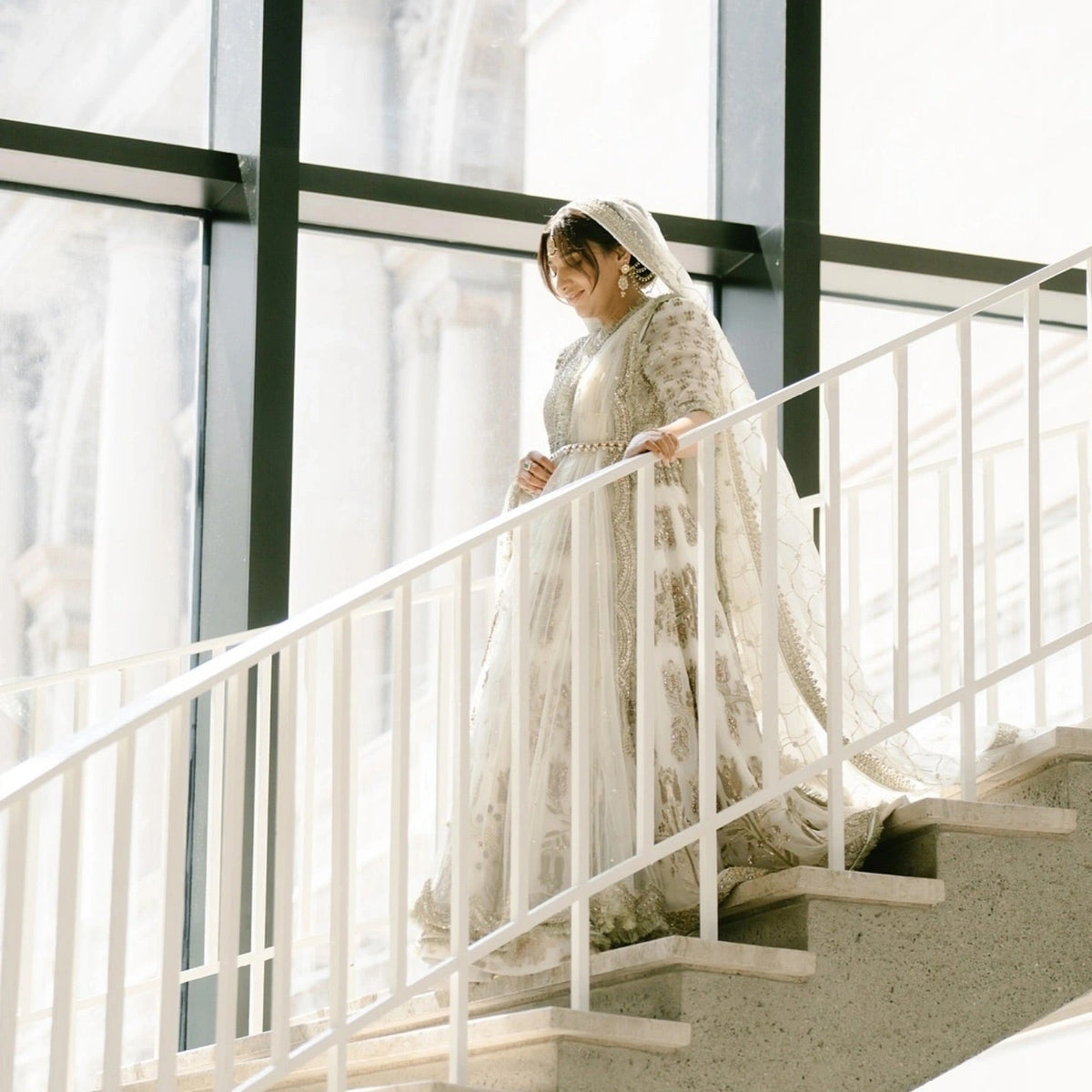 Hussain Rehar Saheda ivory formal gown side view with trailing dupatta on staircase