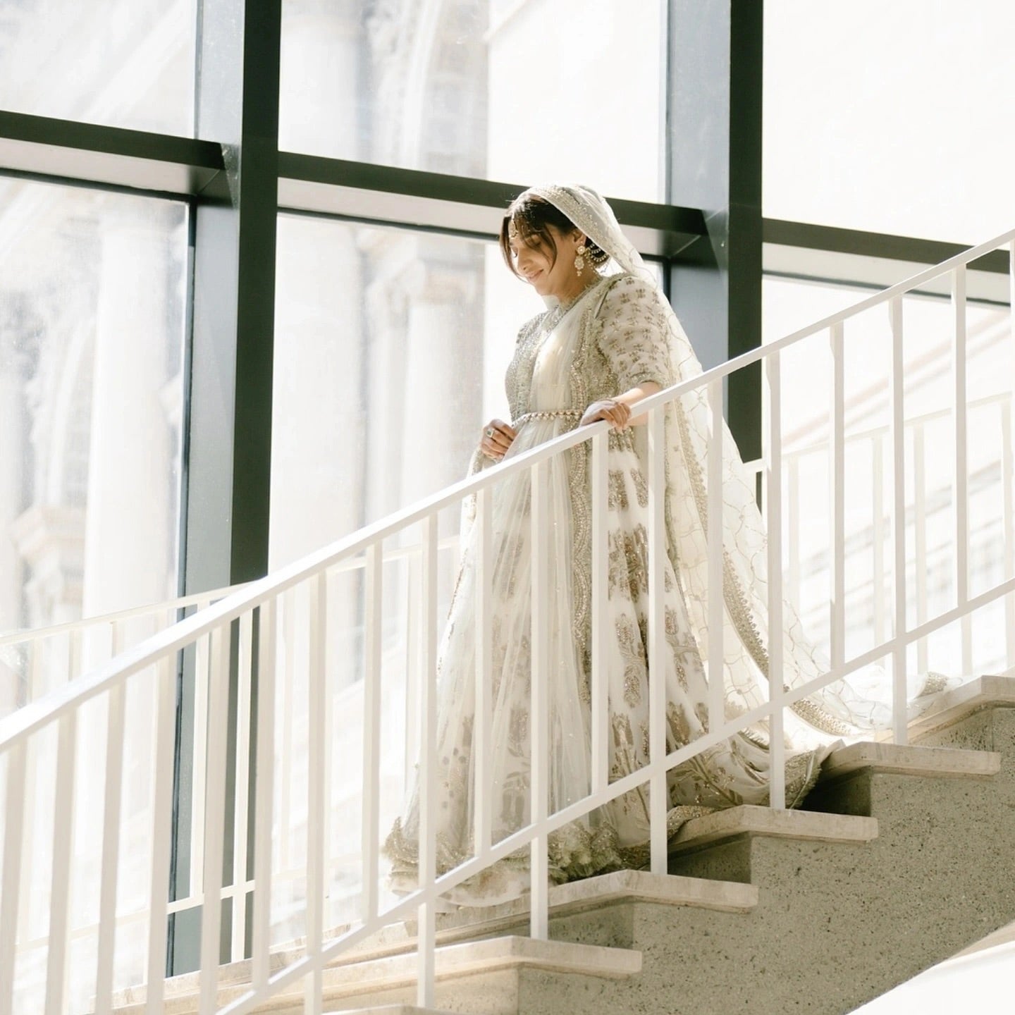 Hussain Rehar Saheda ivory formal gown side view with trailing dupatta on staircase