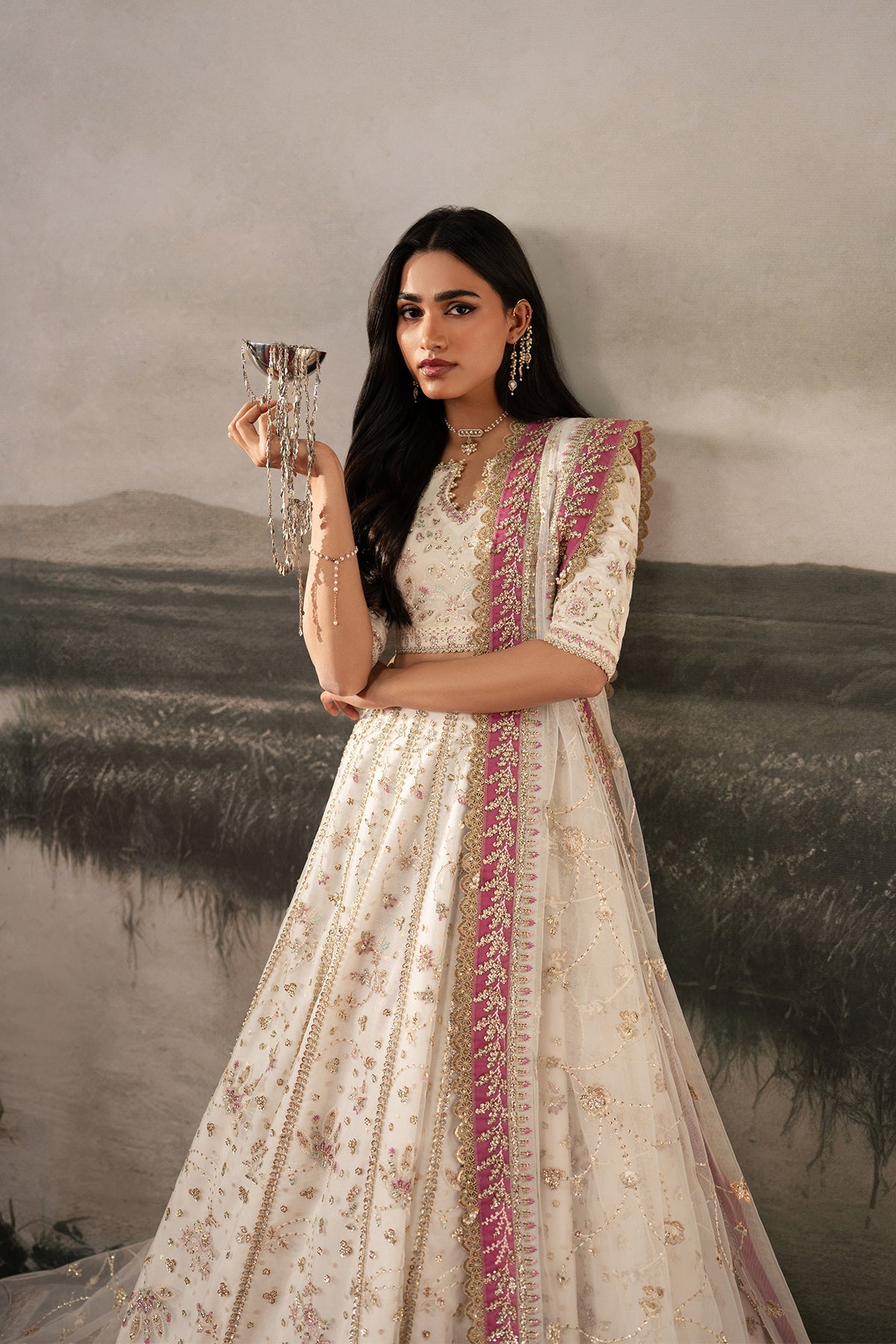 Parure, made by MAIRAZ — white with pink and green accents lehenga choli, seated view showing lehenga