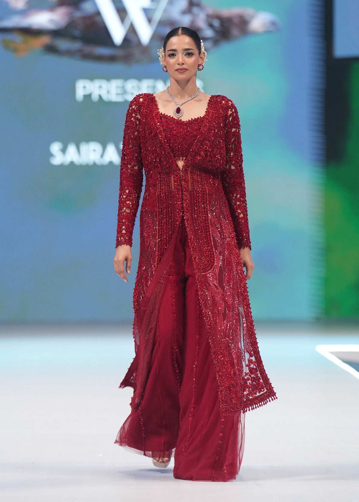 Crimson Desire, made by MAIRAZ — full-length runway front view of the red net cape, bustier and sharara pants
