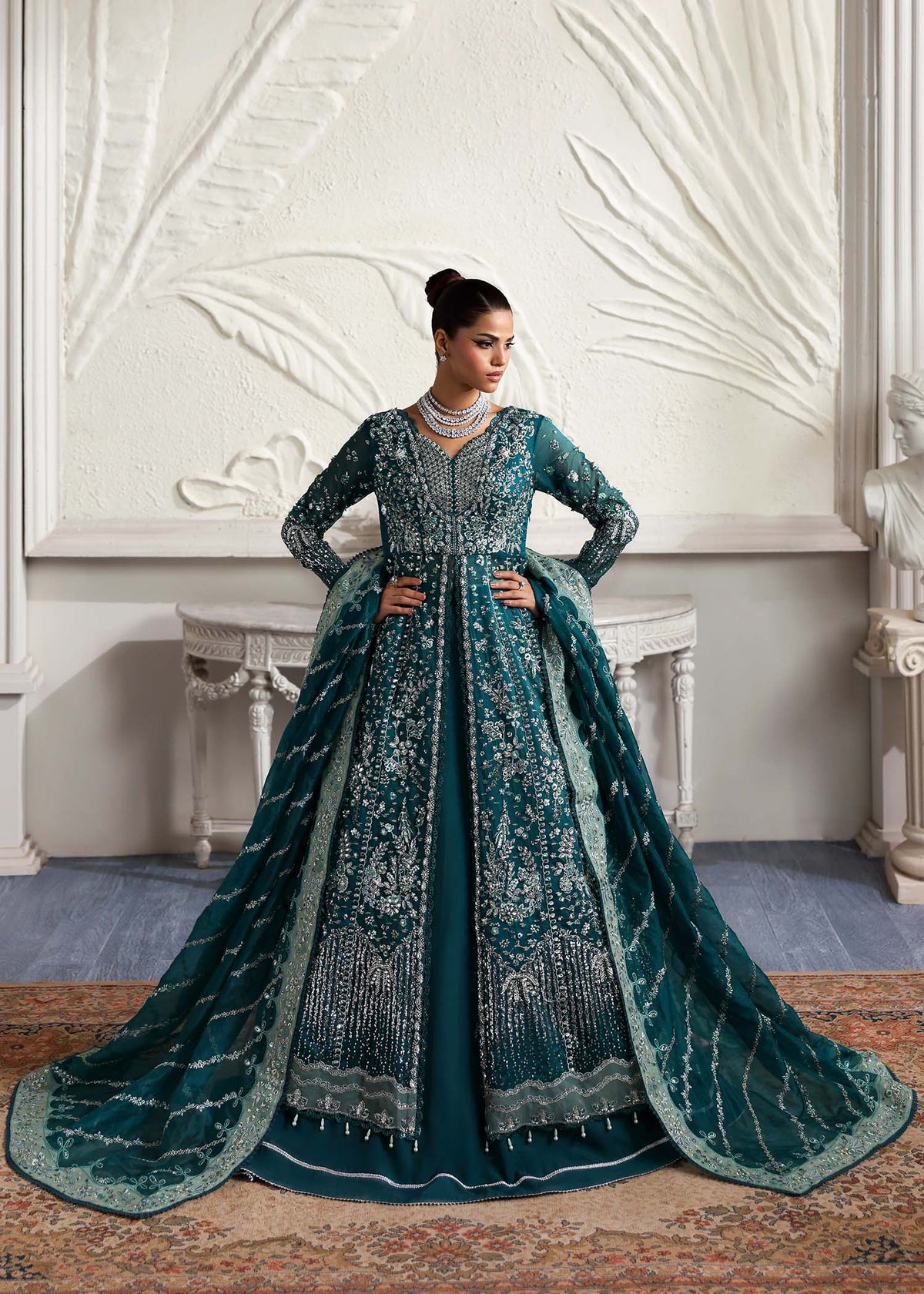 Eclat, made by MAIRAZ — teal green pishwas, seated view showing skirt flare