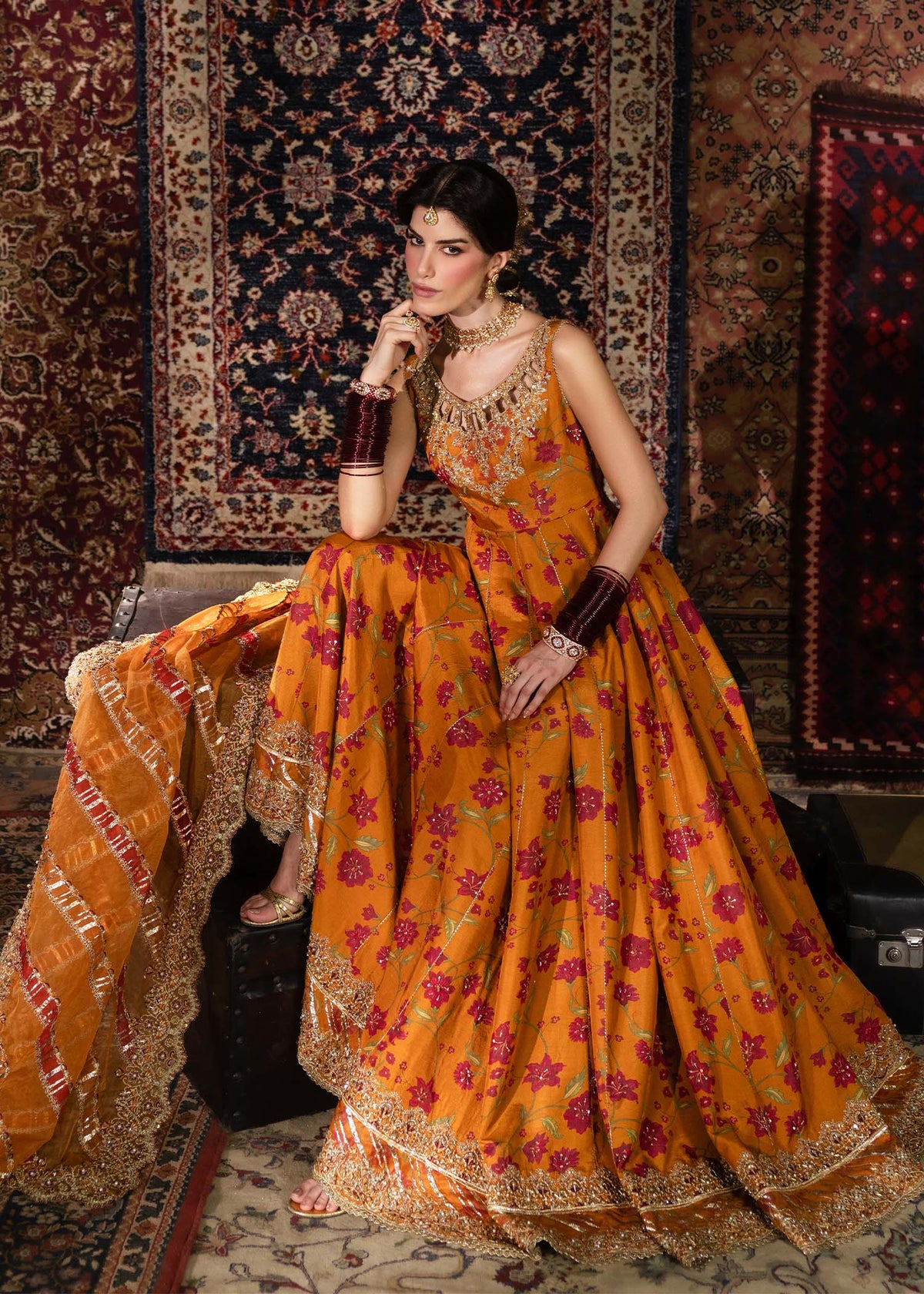 Mehr, made by MAIRAZ — rust pishwas, seated view showing pishwas flare