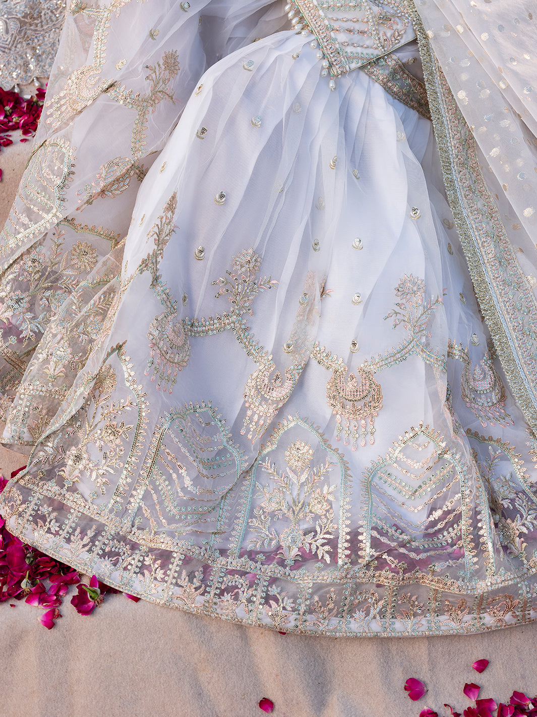 Sj 26170, made by MAIRAZ — seated detail showing the white organza gharara and embroidered border