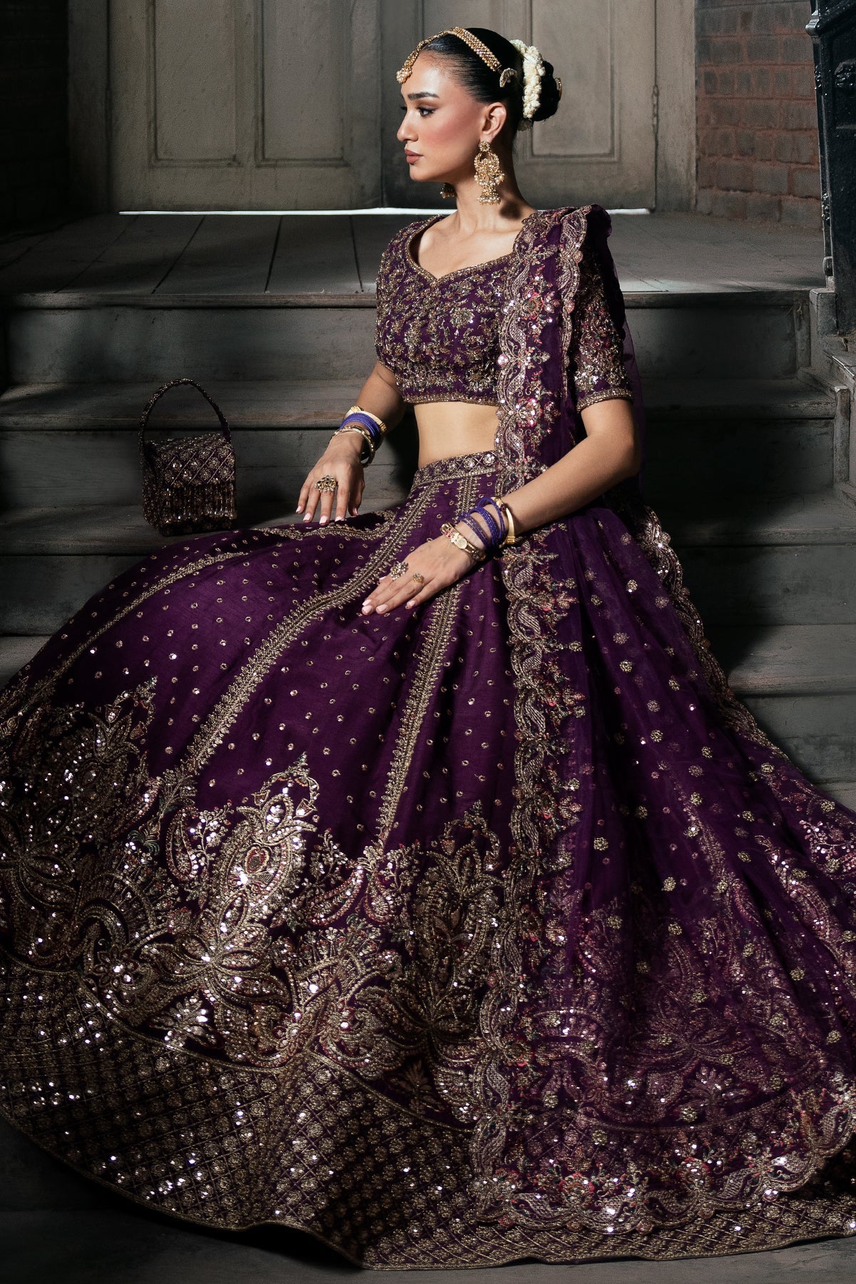 Zarnoor, made by MAIRAZ — deep purple lehenga choli, seated view showing lehenga border and dupatta