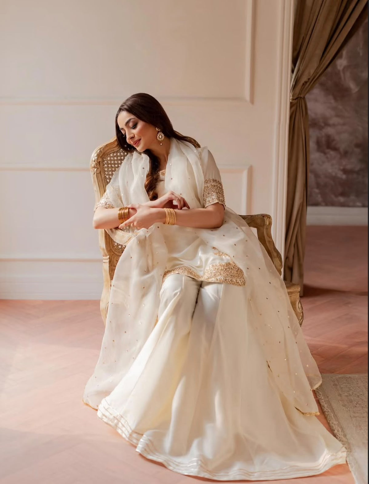 Shanzay & Anooshay White Sharara Style by MAIRAZ — seated full outfit view showing flared sharara and dupatta